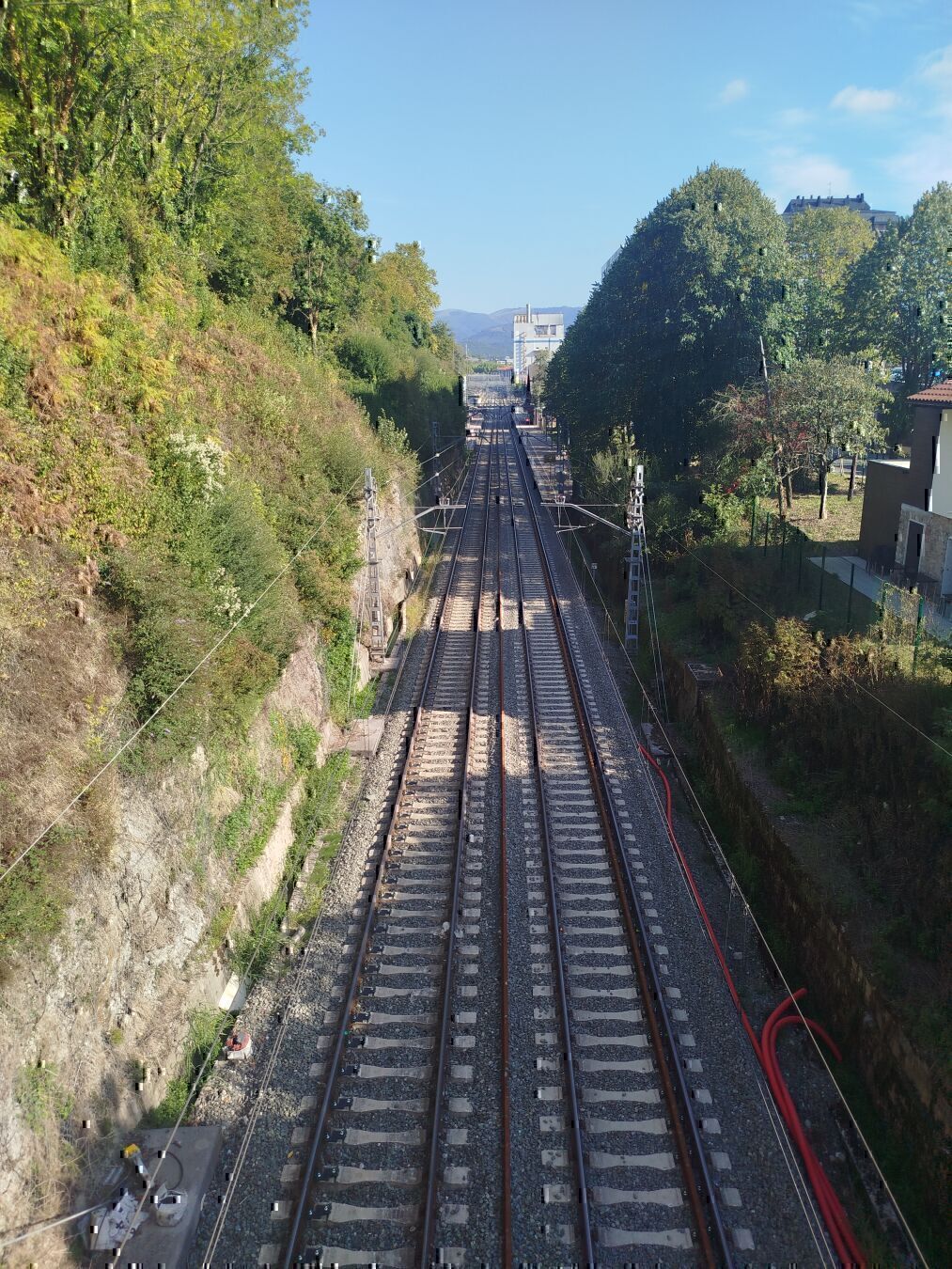 Lezo eta Errenteria arteko trenbidearen tramo zuzena. bi trenbide kilometro bateko zati zuzenean, zuhaitz, etxe eta fabrikaz inguratua.