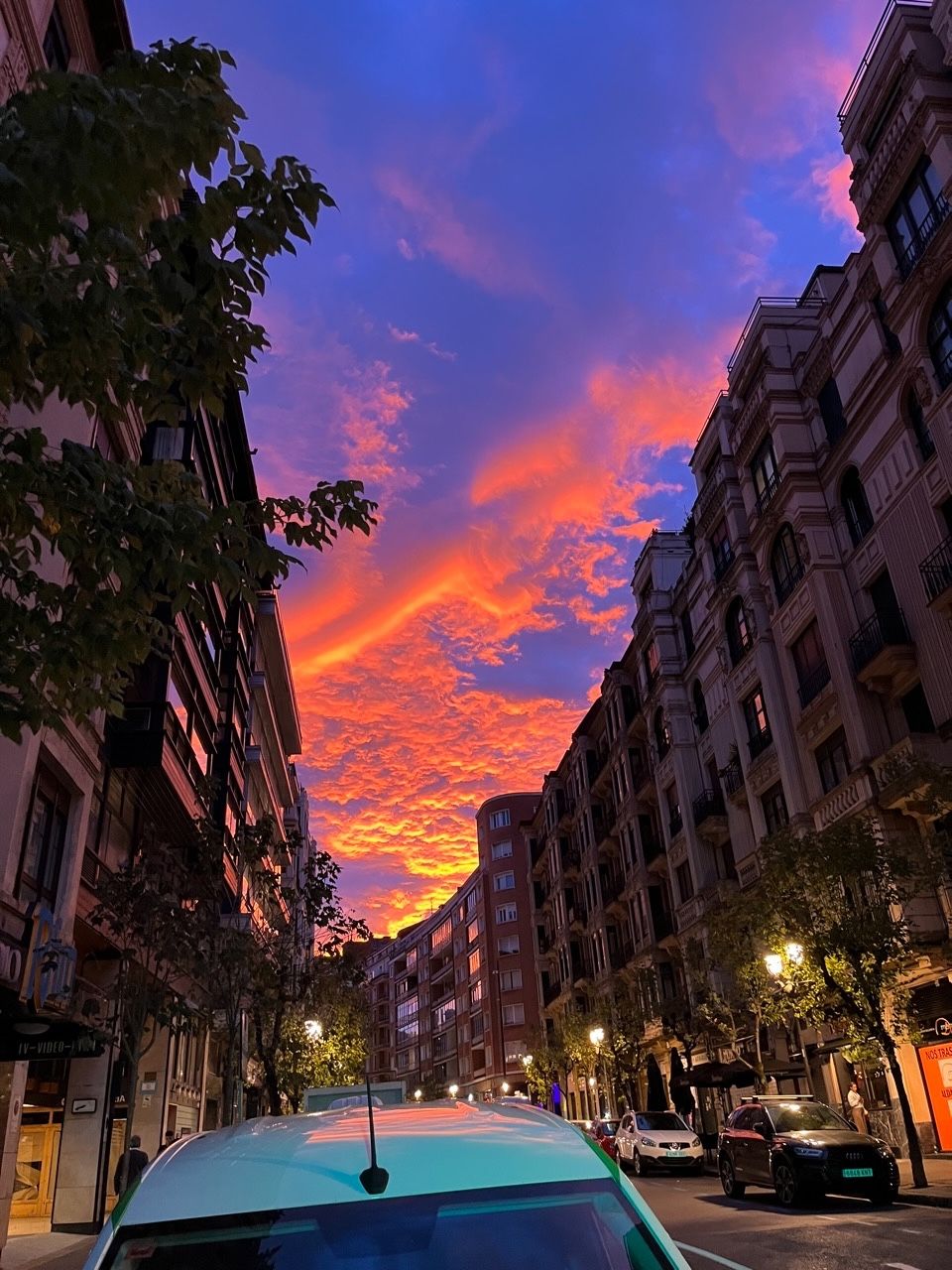 Bilboko Urkixo zumarkalea Arrikibar plazatik ikusita. Argazkian zerua da nabarmentzen dena: more kolorea dauka, eta hodiek kolore laranja bizi-bizia dute, egunsentiko eguzkiaren eraginez.