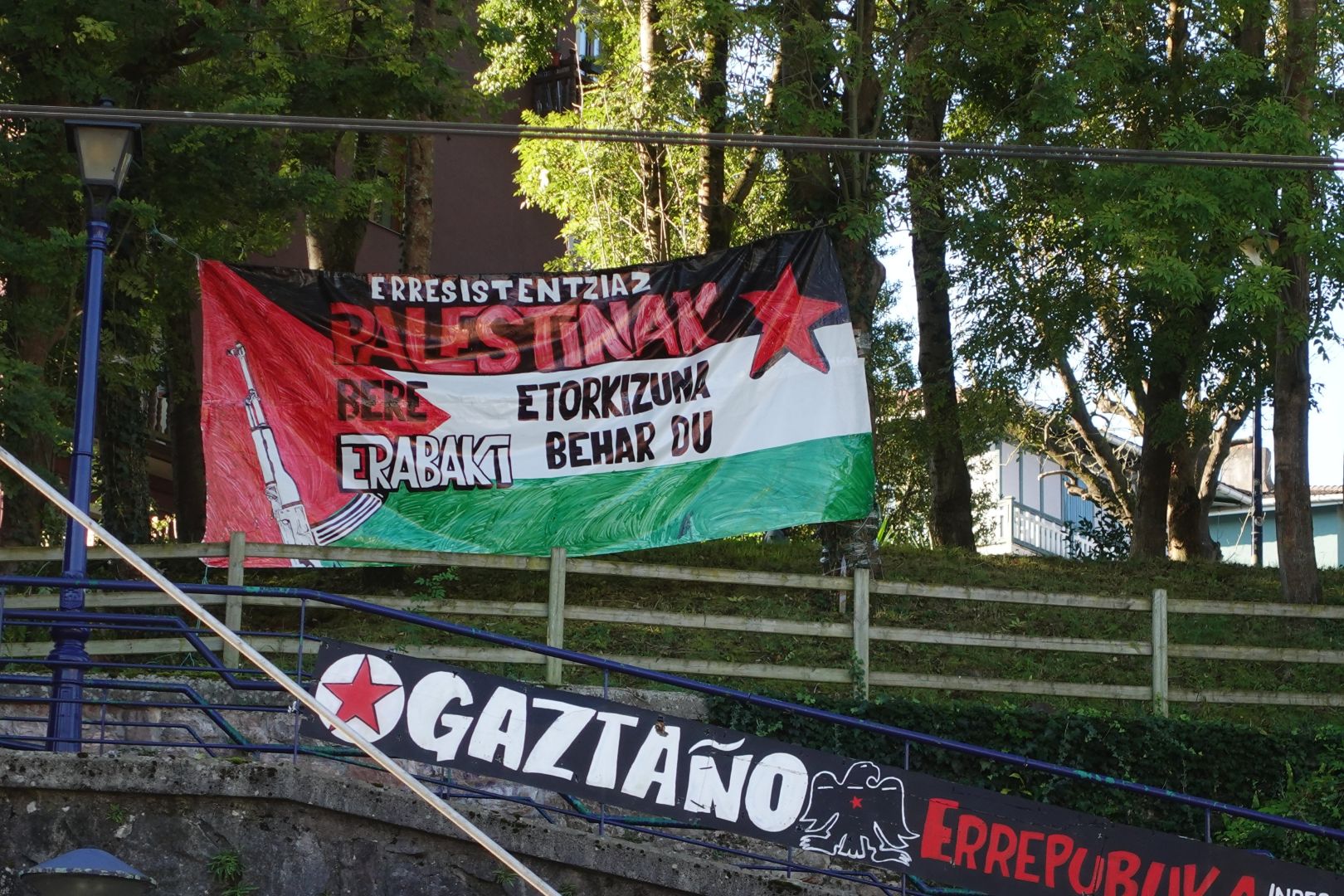 Oreretako gaztaño auzoko pankarta bat. Pankarta Palestinako bandera da, fusil bat duela triangelu gorriaren gainean, bai eta izar gorri bat goiko eskuineko ertzean. Testuak halaxe dio: Erresistentziaz Palestinak bere etorkizuna erabaki behar du.
