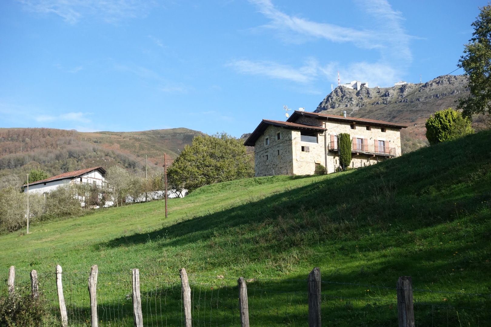 Berako Kaule auzoko Gainekoborda (eskubi) eta Maletena (ezker) etxeak agertzen dira, eta fondoan Larhun mendiaren tontorra.